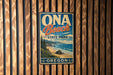 A vintage-style metal sign for Oga Beach State Park in Oregon, featuring a scenic coastal landscape with mountains, trees, and the ocean.