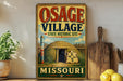 A vintage-style sign for the Osage Village State Historic Site in Missouri, featuring an illustration of a Native American teepee and the text "OSAGE VILLAGE" and "MISSOURI" prominently displayed.