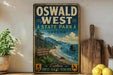A vintage-style sign for Oswald West State Park in Oregon, featuring a scenic coastal landscape with mountains, forests, and ocean views.