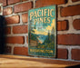 A vintage metal sign for Pacific Pines State Park in Washington, featuring a scenic illustration of the park's natural surroundings.