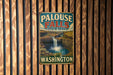 A vintage metal sign for Palouse Falls State Park in Washington, featuring a waterfall and a scenic landscape.