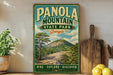 A vintage-style sign for Panola Mountain State Park in Georgia, featuring a scenic mountain landscape with a pine tree and a wooden cutting board.