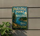 A vintage-style sign for Paradise Point State Park in Washington, featuring a scenic landscape with a mountain, pine trees, and a body of water.