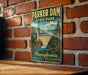 A vintage-style metal sign for Parker Dam State Park in Pennsylvania, featuring a scenic illustration of the dam and surrounding landscape.