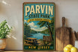 A vintage-style sign for Parvin State Park, featuring a scenic image of a lake and forest, is displayed on a shelf next to a wooden cutting board and some lemons.