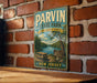 A vintage-style metal sign for Parvin State Park in New Jersey, featuring a scenic image of the park and a picnic area.