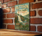 A vintage-style metal sign for Pattison State Park in Wisconsin, featuring a waterfall and forest scenery.