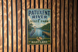A vintage metal sign for Patuxent River State Park in Maryland, featuring an illustration of a heron and a wooden dock.