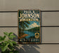 A vintage-style metal sign for Paul B. Johnson State Park in Mississippi, featuring a scenic landscape with pine trees, a lake, and a cloudy sky.