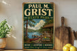 A vintage-style sign for Paul M. Grist State Park, featuring a scenic illustration of a lake, cabin, and mountains.