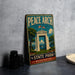 A vintage-style metal sign for Peace Arch State Park in Washington, featuring an illustration of the entrance to the park.