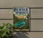 A vintage-style metal sign for the state park in Florida, featuring a peacock and a scenic landscape.
