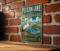A vintage-style metal sign for Pelican Lake State Recreation Area in South Dakota, featuring a white pelican and a scenic landscape.