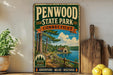 A vintage-style metal sign for Penwood State Park in Connecticut, featuring a scenic illustration of a forest and a lake.