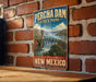 A vintage-style metal sign for Percha Dam State Park in New Mexico, featuring a scenic illustration of the dam and surrounding landscape.