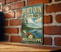 A vintage-style metal sign for Percy Quinn State Park in Mississippi, featuring a scenic image of a lake and a boat.