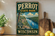 A vintage-style sign for Perrot State Park in Wisconsin, featuring a scenic landscape with a river, mountains, and a sailboat.