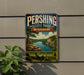 A vintage metal sign for Pershing State Park in Missouri, featuring a scenic landscape with a river, mountains, and a person in a canoe.