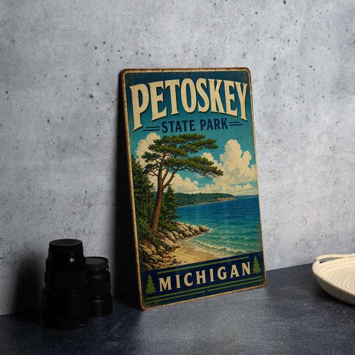 A vintage-style metal sign for Petoskey State Park in Michigan, featuring a scenic landscape with a pine tree and a body of water.