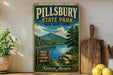 A vintage-style sign for Pillsbury State Park in New Hampshire, featuring a scenic mountain landscape with a lake and pine trees.
