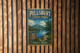 A vintage metal sign for Pillsbury State Park in New Hampshire, featuring a scenic mountain landscape and a lake.