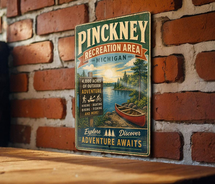 A vintage-style metal sign for the Pinckeney Recreation Area in Michigan, featuring a scenic illustration of a lake, forest, and canoe.