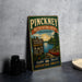 A vintage metal sign advertising the Pinckney Recreation Area in Michigan, featuring a scenic image of a lake and forest.