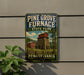 A sign for Pine Grove Furnace State Park in Pennsylvania, featuring a red brick building and a tree in the background.