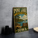 A vintage-style sign for Pine Lake State Park in Iowa, featuring a scenic image of the lake and surrounding landscape.