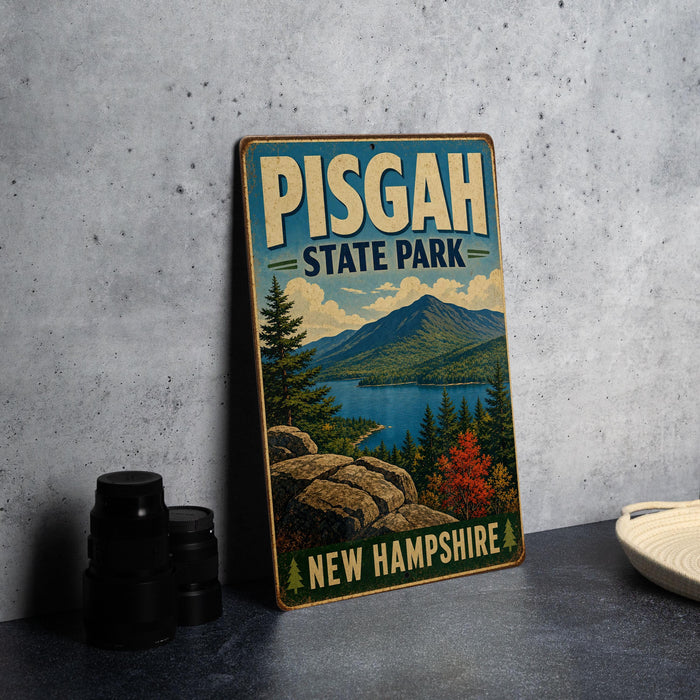 A vintage-style sign for Pisgah State Park in New Hampshire, featuring a scenic landscape with mountains, forests, and a lake.