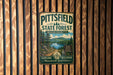 A vintage metal sign for Pittsfield State Forest in Massachusetts, featuring a scenic landscape with pine trees, a lake, and mountains.