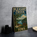 A vintage-style metal sign for Pleasant Creek State Recreation Area in Iowa, featuring a scenic illustration of a river and forest.