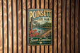 A vintage-style metal sign for Poinsett State Park in South Carolina, featuring a scenic image of a wooden bridge and a lake surrounded by trees.