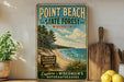 A vintage-style sign for Point Beach State Forest in Wisconsin, featuring a scenic beach landscape with pine trees and a lake.