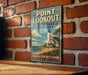 A vintage-style metal sign for Point Lookout State Park in Maryland, featuring a lighthouse and a coastal landscape.