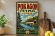 A vintage-style metal sign for Pokagon State Park, Indiana, featuring a scenic illustration of a river and a covered bridge.