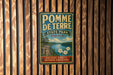 A vintage-style metal sign for Pomme de Terre State Park in Missouri, featuring a scenic landscape with a lake and mountains.