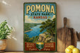 A vintage-style poster for Pomona State Park, Kansas, featuring a scenic landscape with a lake and mountains.