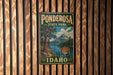 A vintage metal sign for Ponderosa State Park in Idaho, featuring a scenic landscape with a lake and mountains.
