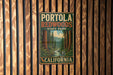 A vintage-style metal sign for Portola Redwoods State Park in California, featuring a scenic illustration of the park's forested landscape.
