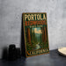 A vintage-style metal sign for Portola Redwoods State Park in California, featuring a scenic illustration of the park's forest and a stream.