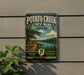 A vintage-style sign for Potato Creek State Park in Indiana, featuring a scenic image of a river and a wooden boardwalk.