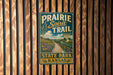 A vintage metal sign for the Prairie Spirit Trail in State Park, Kansas, mounted on a wooden wall.