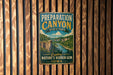 A vintage metal sign for Preparation Canyon State Park, featuring a scenic illustration of the canyon and a river.