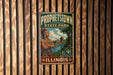 A vintage-style metal sign for "Prohétown State Park" in Illinois, featuring an illustration of a Native American man with a headdress.
