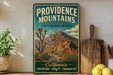 A vintage-style metal sign for Providence Mountains, California, featuring a desert landscape with a mountain in the background.