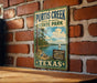 A vintage metal sign for Purtis Creek State Park in Texas, featuring a scenic illustration of a lake, trees, and a sailboat.
