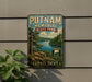 A vintage metal sign for Putnam Memorial State Park in Connecticut, featuring a scenic landscape with a lake and mountains.