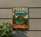 A vintage-style sign for the Pyramid State Recreation Area in Illinois, featuring a mountain landscape and a lake.