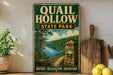 A vintage-style sign for Quail Hollow State Park in Ohio, featuring a scenic illustration of a river, forest, and a stone marker.